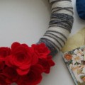 Gray and winter white yarn wreath with felted red flowers