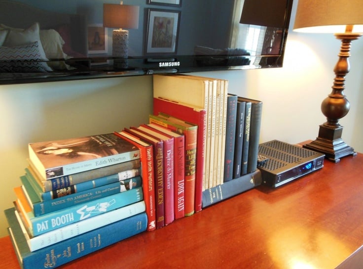 https://www.remodelaholic.com/wp-content/uploads/2015/06/use-stacks-of-books-to-hide-TV-cords-and-wires-via-Love-Coming-Home.jpg