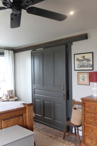 Bedroom With Large Grey Barn Door And Wooden Bed And Dresser Set