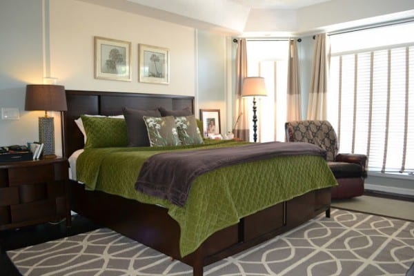 Bedroom With Large Window And Dark Wood Headboard And Frame And Nighstands With Green And Brown Bedding And Dark Leather Rocker Recliner