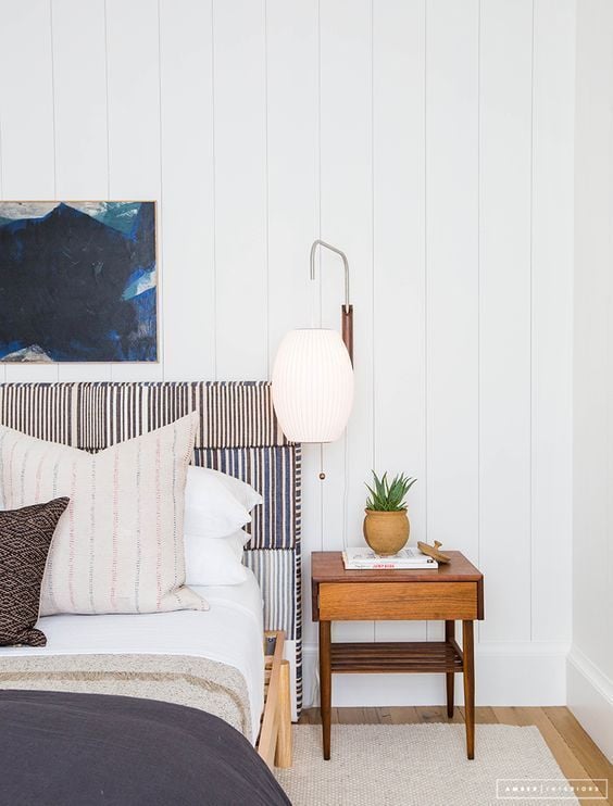 White Shiplap Wall With Natural Wood Night Stand, Blue Artwork Above Blue Striped Headboard Bed With Blue Comforter