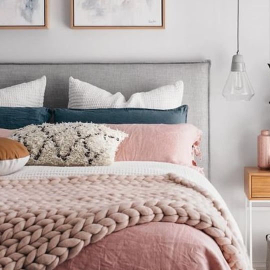 Bedroom With White Walls, Grey Headboard, Pink Comforter And Pillows With Blue And White Accents