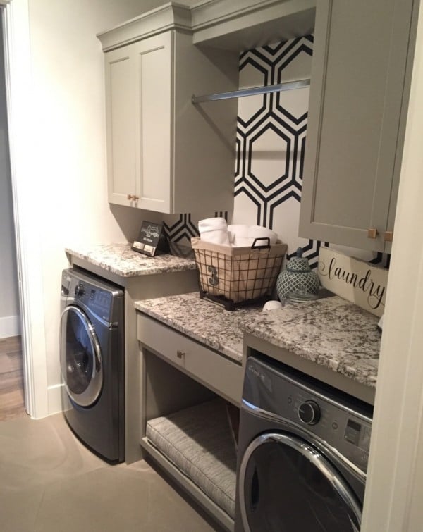 Washroom With Front Loading Washer And Dryer With Counterspace On Top, Different Levels, Drawers, Cupboard And Hanging Rod And Accent Wall With Patterned Wallpaper