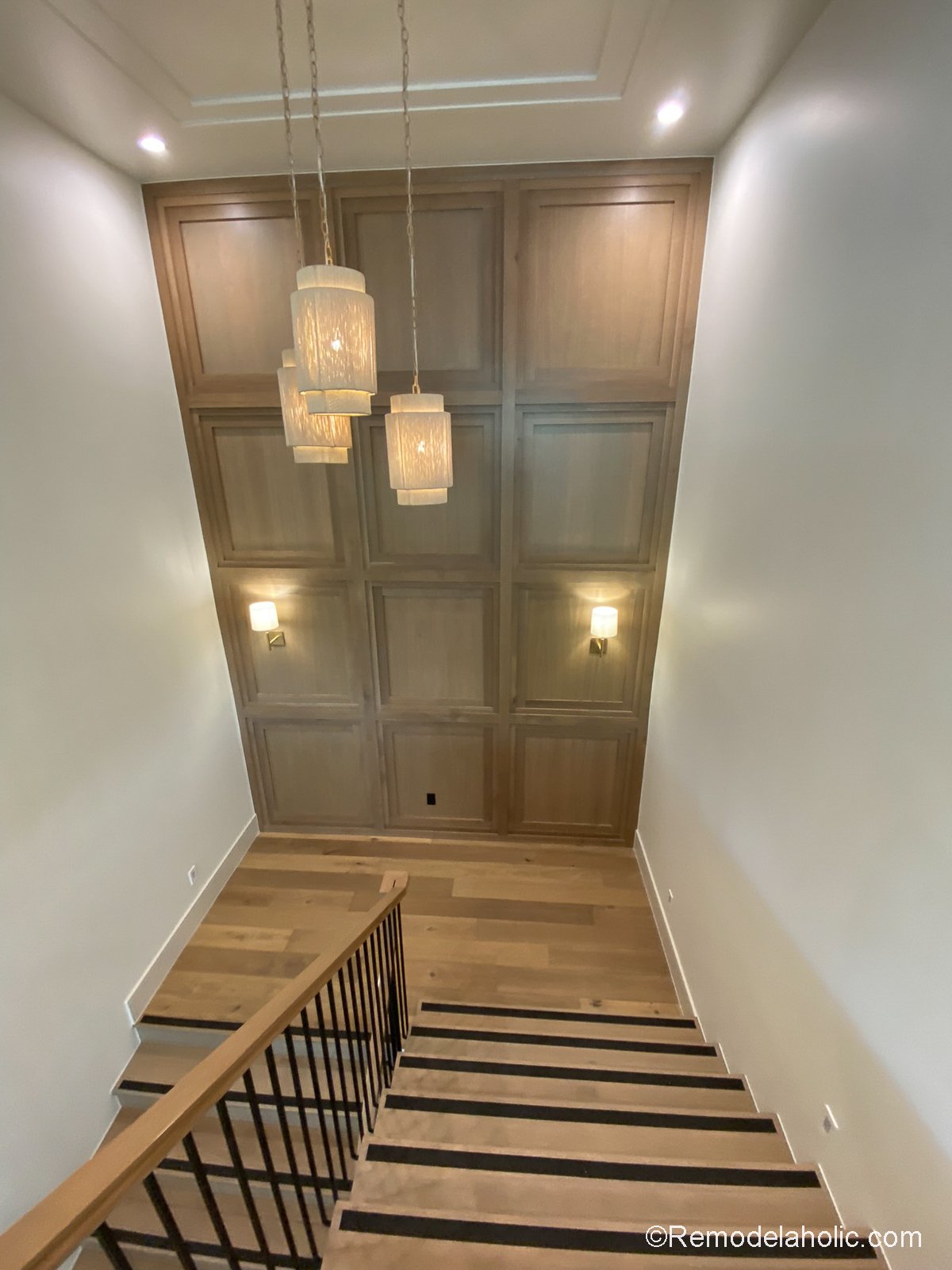 Tall accent wall in stairs using millwork molding's of stained wood